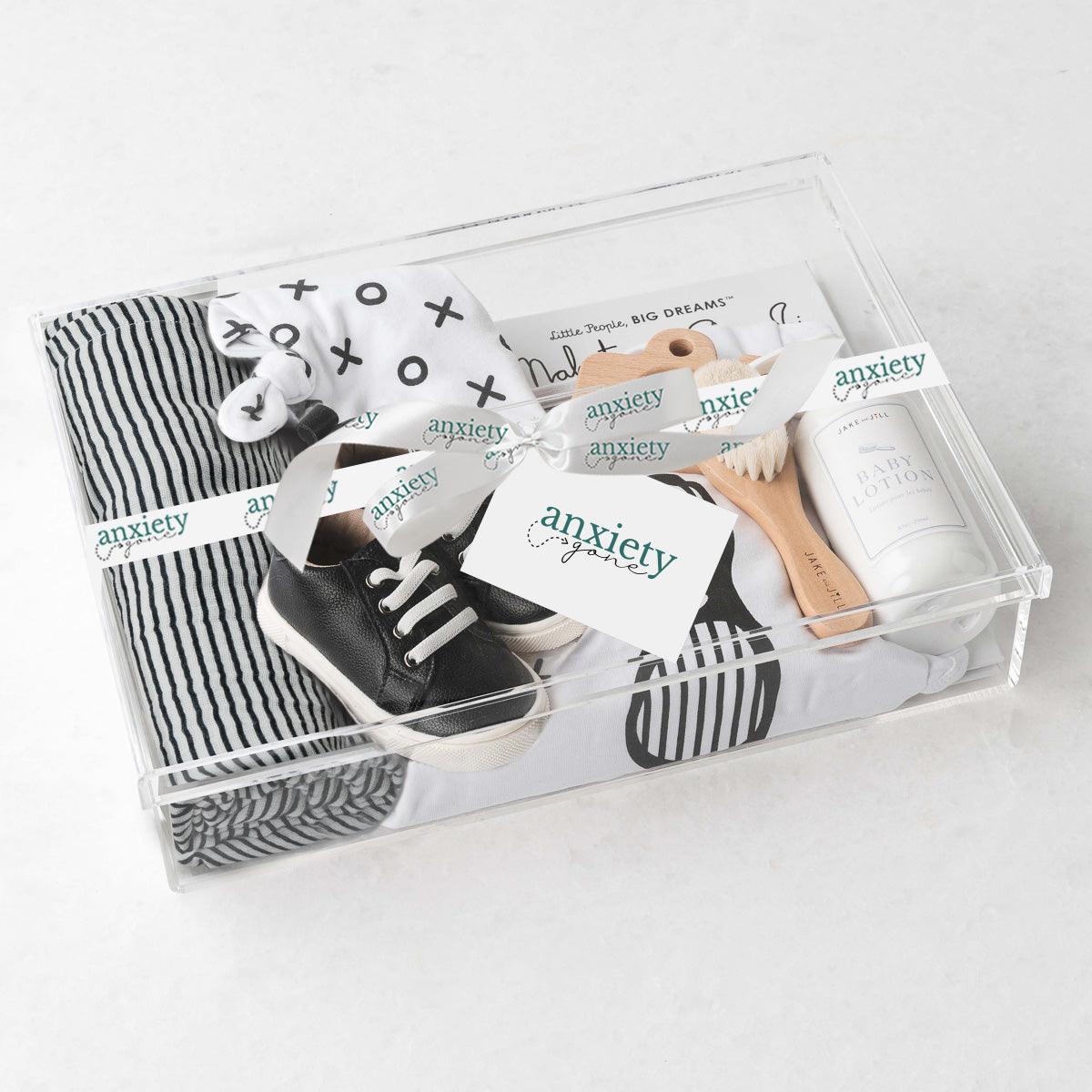 Cool Dude New Baby Gift Box – Luxurious baby boy gift set featuring a muslin swaddle, XO onesie, knot hat, goat brush, running shoes, baby lotion, wooden camera teether, and Mahatma Gandhi book. Perfect for baby showers, personalized baby gifts, and stylish newborn gifts.

