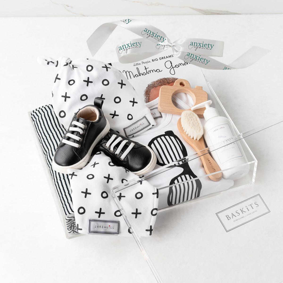 Cool Dude New Baby Gift Box – Luxurious baby boy gift set featuring a muslin swaddle, XO onesie, knot hat, goat brush, running shoes, baby lotion, wooden camera teether, and Mahatma Gandhi book. Perfect for baby showers, personalized baby gifts, and stylish newborn gifts.

