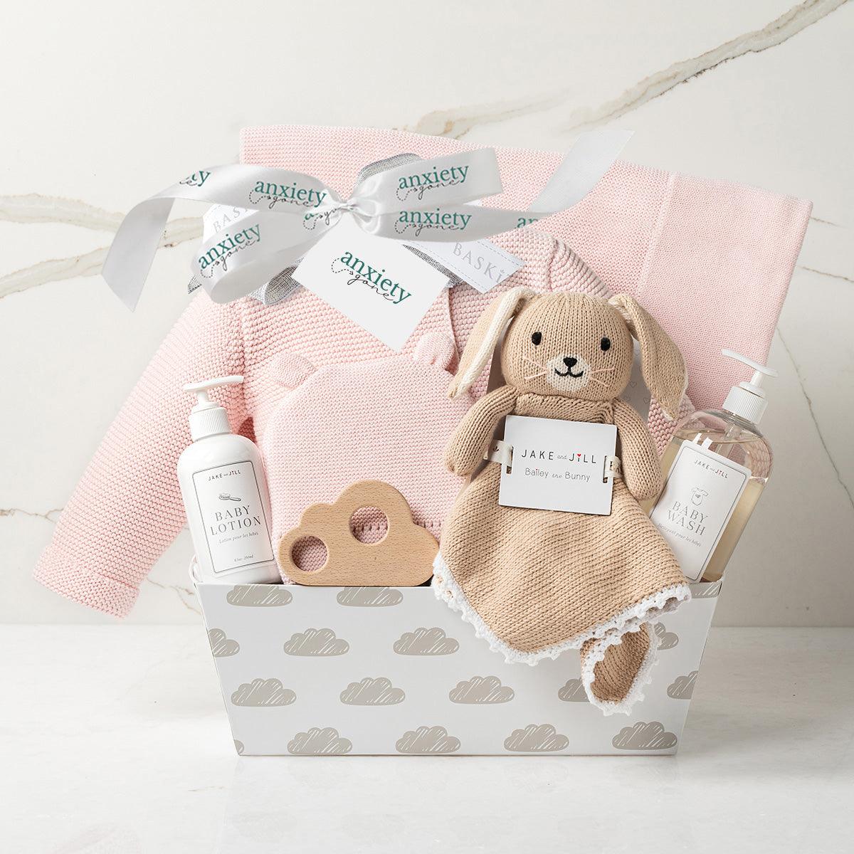 Bundle of Joy Baby Girl Gift Basket – Includes cotton knit sweater, matching hat, cozy blanket, wooden cloud teether, lovie, baby lotion, baby wash, and keepsake cloud base. Ideal for baby showers, personalized baby gifts, and newborn celebrations. Available in pink or grey for a gender-neutral option.