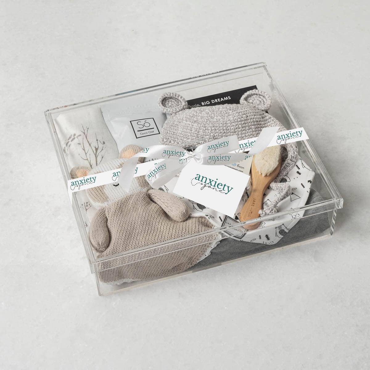 Baby Bear Gift Box – Premium new baby gift basket featuring a crochet knit toque with bear ears, cotton onesie, goat brush, forest-patterned swaddle, plush panda, coconut &amp; oat milk bath, and classic &quot;Brown Bear, Brown Bear&quot; book. Ideal for baby showers, birthdays, or gender-neutral gifts for a newborn.