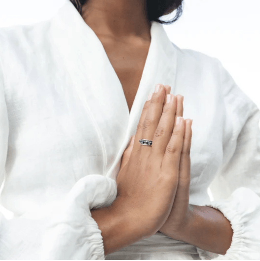 Sterling silver meditation spinning ring with 10KT Yellow Gold edges and large Black CZ spinning band, displayed with complimentary tin and travel pouch