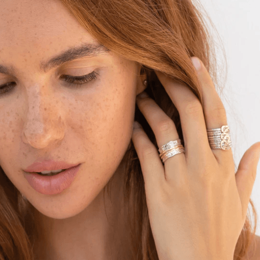 Breeze meditation anxiety ring in sterling silver with 9KT rose gold and yellow gold spinning bands, scalloped edge pattern, displayed with complimentary tin and travel pouch