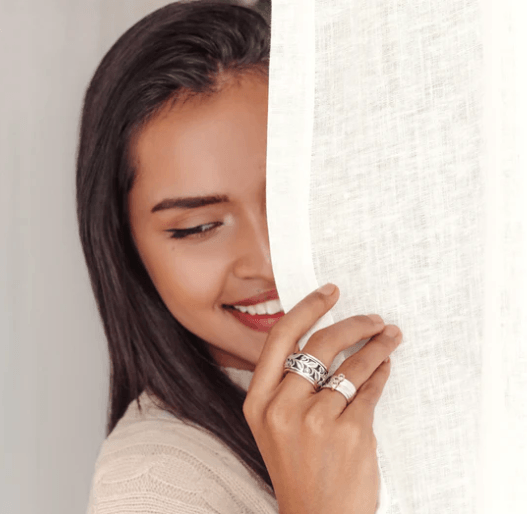 Earthy Sterling Silver Spinner Ring for womenwith Yellow Gold edges, spinning leaf detail band, and CZ stones, displayed with complimentary MeditationRings Tin and Travel Pouch