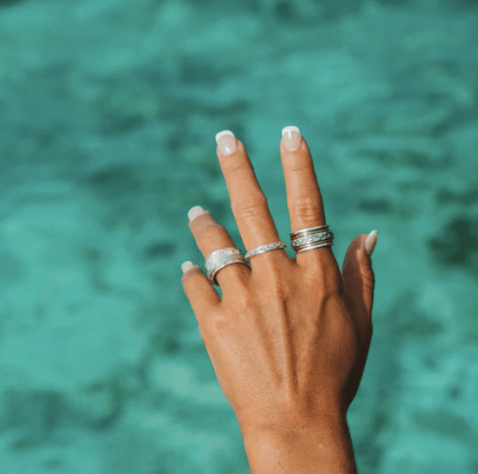 Sterling Silver Spinning Ring with silver flower pattern, Rose Gold and Yellow Gold spinning bands, displayed with complimentary MeditationRings Tin and Travel Pouch