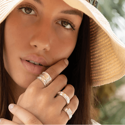 Karma Sterling Silver Spinner Ring with intricate floral detailing and two spinning bands, displayed with complimentary tin and travel pouch