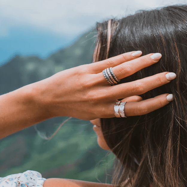 Sterling Silver Spinner Ring with flower pattern edges, Rose Gold filigree band, and Silver hand-scraped band, displayed with complimentary MeditationRings Tin and Travel Pouch