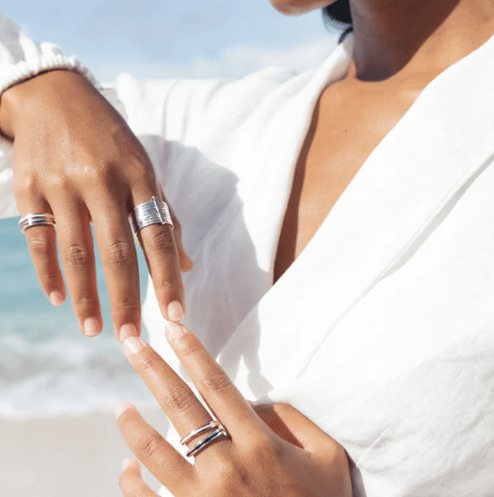 Shanti Silver Spin Ring in sterling silver with black enamel spinning band, displayed with complimentary tin