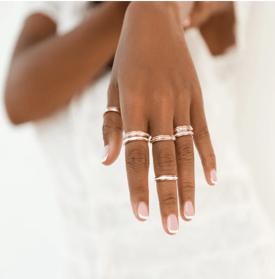 Stackable 14KT Rose Gold Fidget Ring with white enamel spinning band, displayed with complimentary MeditationRings Tin and Travel Pouch