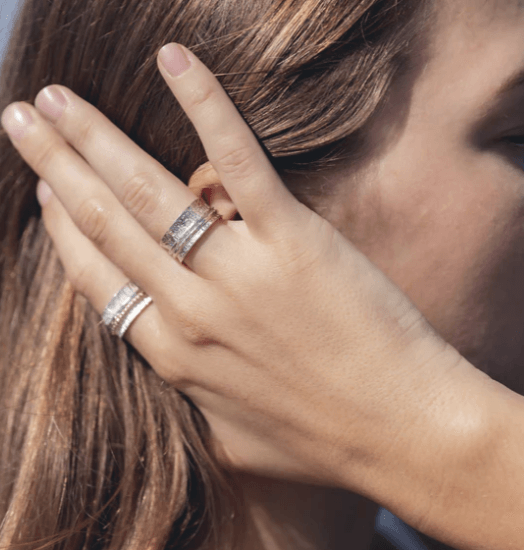 Awaken spinning anxiety ring in sterling silver with a lightly hammered base and two spinning bands, displayed with complimentary tin