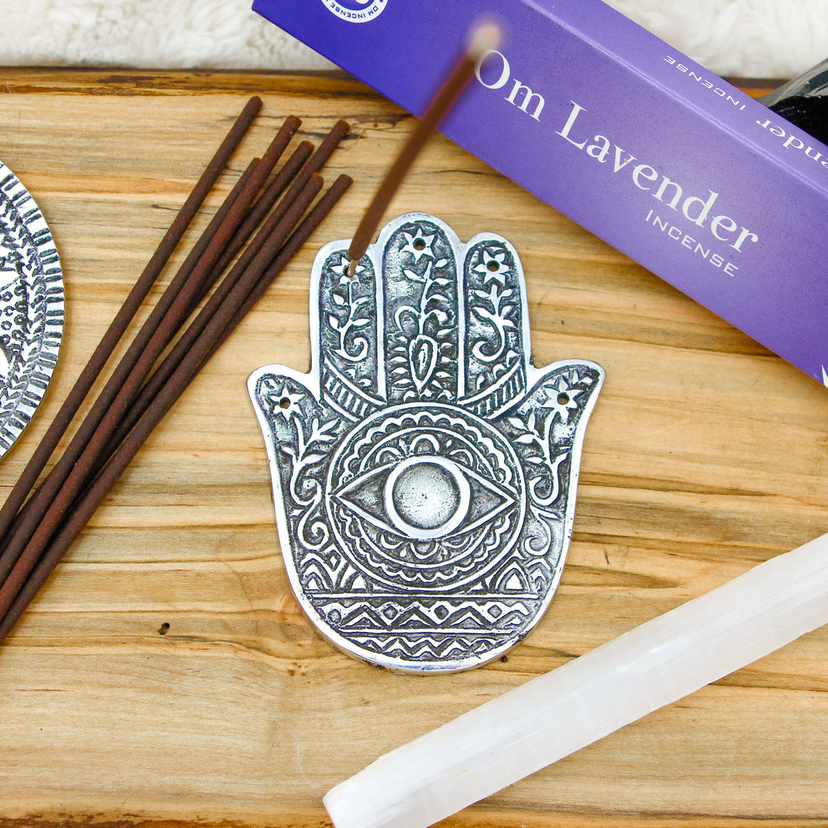 Hand of Compassion Hamsa Aluminum Incense Burner with 5 slots for incense sticks and a base for cones.